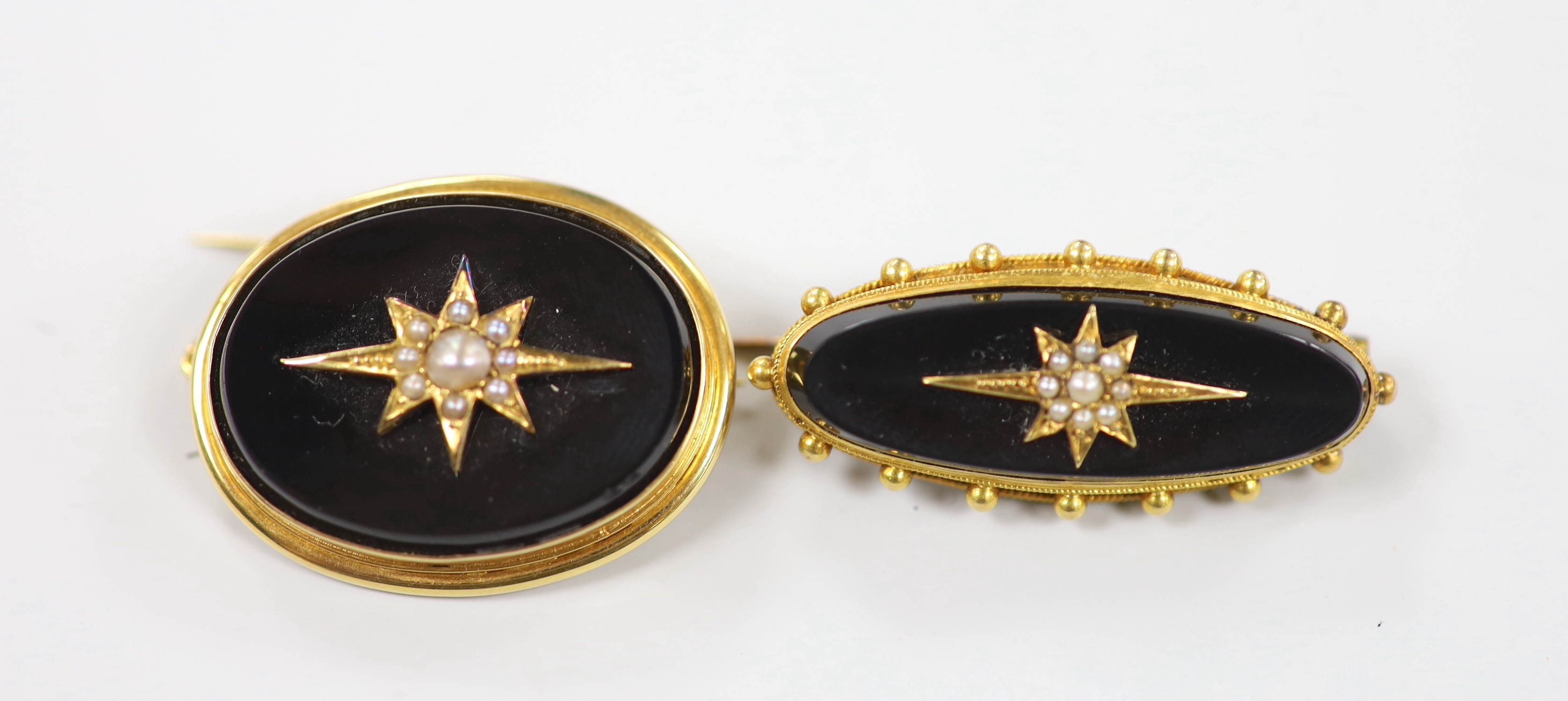 A Victorian 15ct, black onyx and seed pearl set oval mourning brooch, 29mm, gross 10.5 grams, and one other similar yellow metal brooch, 35mm, gross weight 6.3 grams.